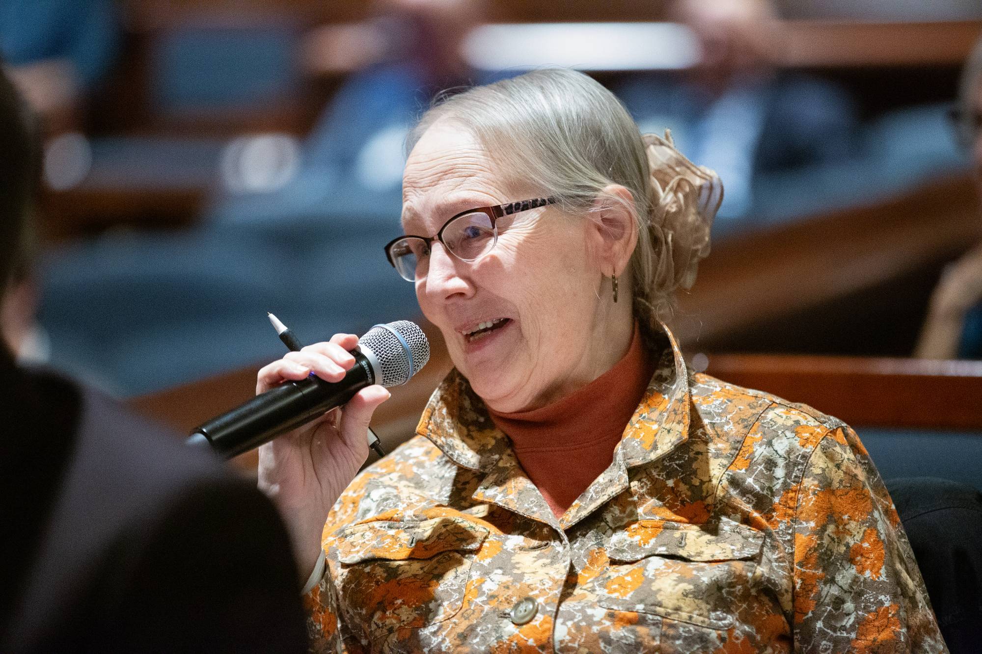 a lady asks a question in a microphone
